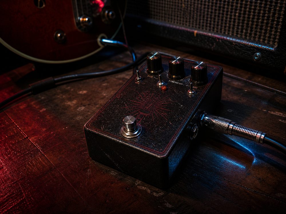 Pedals and guitar gear in a dark studio